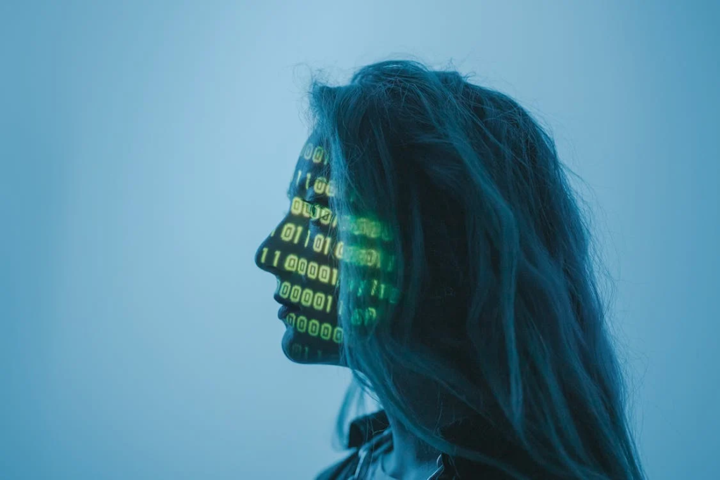 Profile of a woman against a blue background with binary code projected on her face