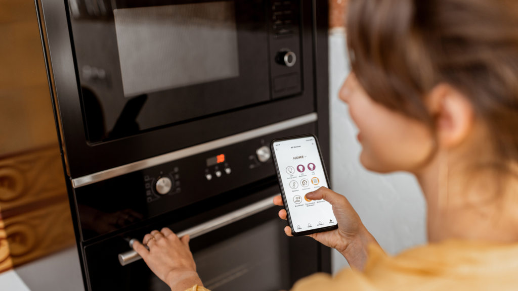 Woman controls her smart oven with her smartphone